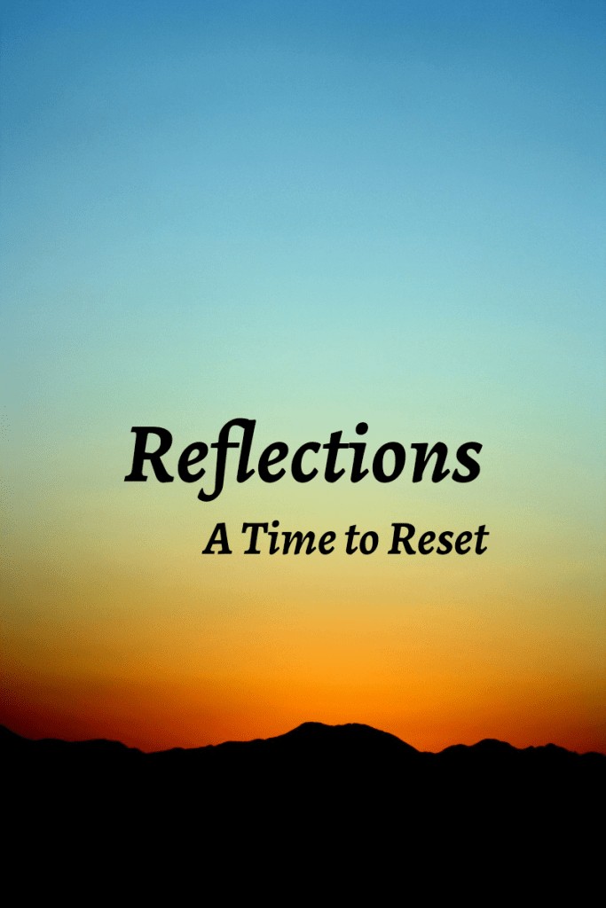 reflections a time to reset image shows a scene of a mountain under a sunset