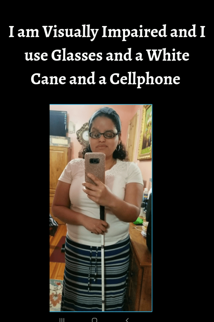 In this image I am standing holding my phone and a white cane and wearing glasses. I am wearing a white shirt and a skirt with blue and white stripes. Text reads I am visually impaired and use glasses and a white cane and a cellphone
