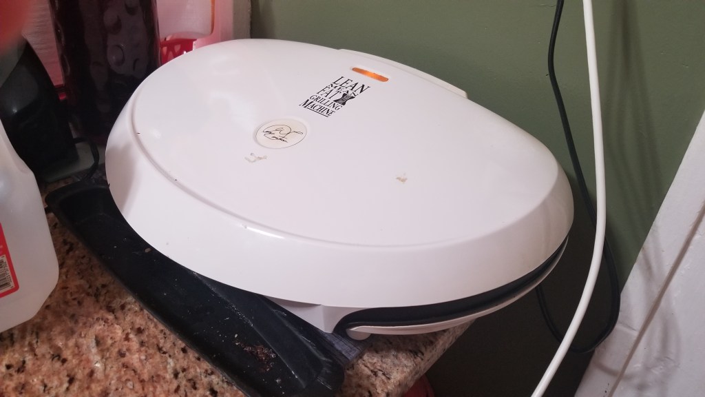A George Foreman grill is on a table in a kitchen