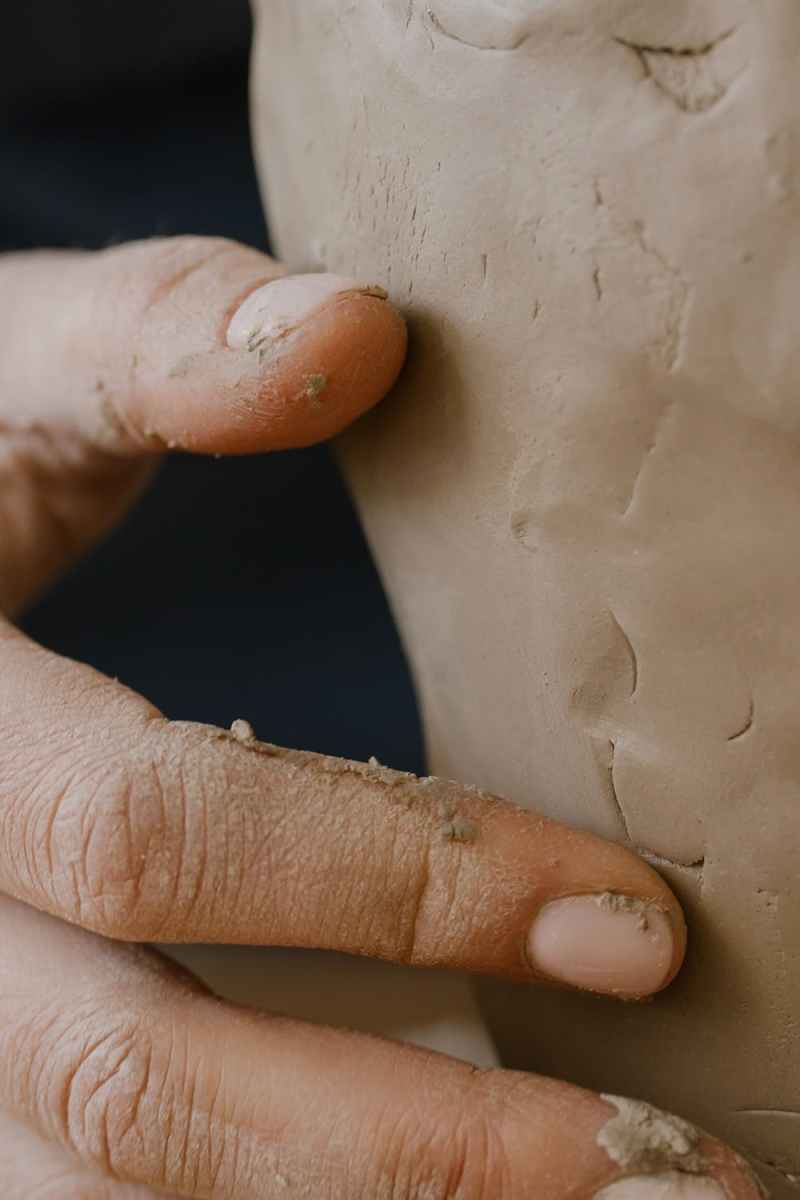 Close up of a person's hand molding a clay pot